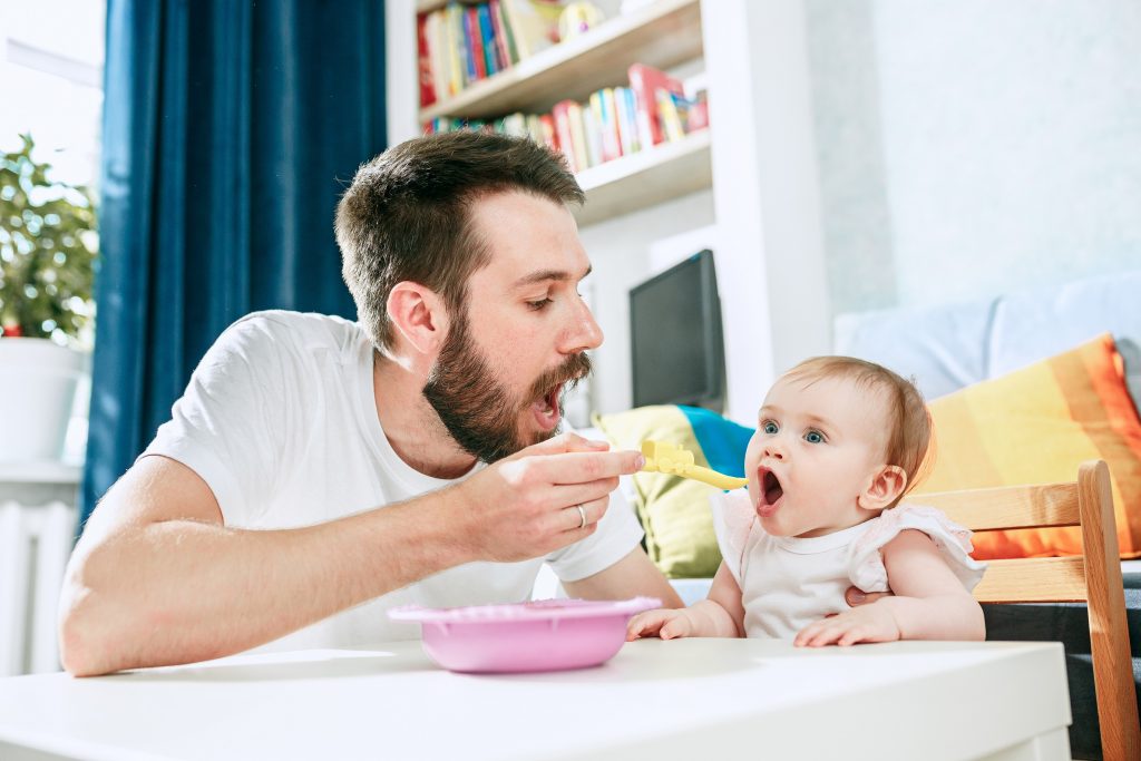 infant feeding firsts - father feeding baby