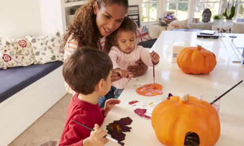 Mom creating fall crafts with young children, toddler and baby-age.